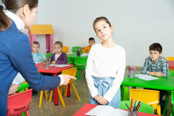 Female teacher scolding naughty student in elementary school class