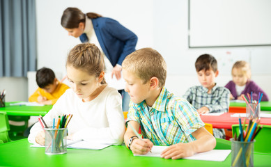 Fototapeta premium Assiduous kids studying in classroom