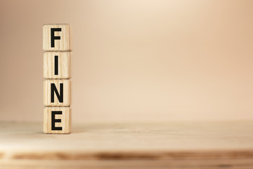 Wooden blocks with the word Fine and judge. Penalty as a punishment for a crime and offense. Financial punishment. Violations of traffic laws. Fraud. Fines can also be used as a form of tax