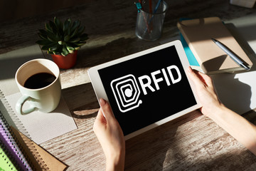 RFID Radio frequency identification technology concept on device screen. Security and automation.