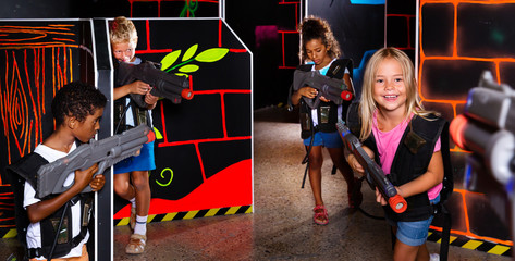 Preteen girls and boys with laser pistols playing laser tag