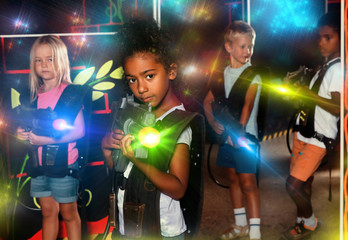 Fototapeta premium Teenager girl with laser pistol posing in laser tag labyrinth