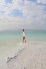 Woman stands on the Death Sea beach in Jordan