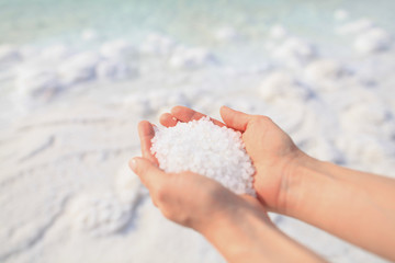 Close-up of the salt from the Death Sea in Jordan in woman<s hands. Atopic skin care. 