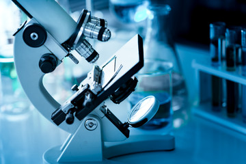 Microscope on the table with others chemical equipment in laboratory