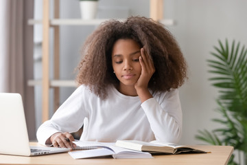 Bored african american teen student tired of learning doing homework