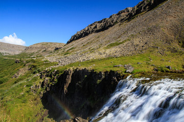 Fototapeta na wymiar Der Dynjandi Wasserfall, einer der schönsten Wasserfälle Islands im Norden der Insel in den Westfjorden, vor blauem Himmel