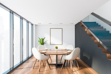 White dining room with stairs and poster