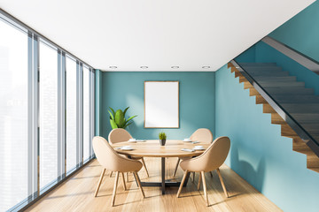 Blue dining room with stairs and poster