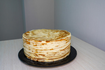 Cook - Confectioner. Cooking a festive multi-layer birthday cake. Scones are smeared with whipped cream.