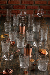 many glasses of different shapes on a wooden background