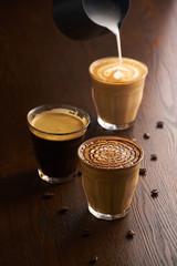 Cups of latte and Cappuccino and espresso on table in cafe.