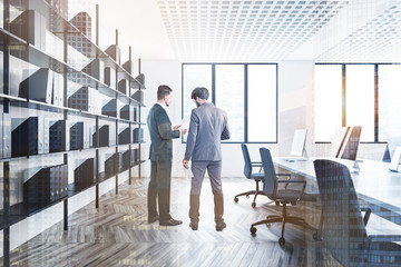 Two managers in white office with bookcase
