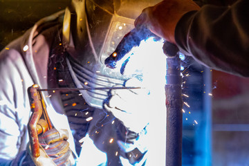 Welding a rusty pipe in a garage. Industrial series.