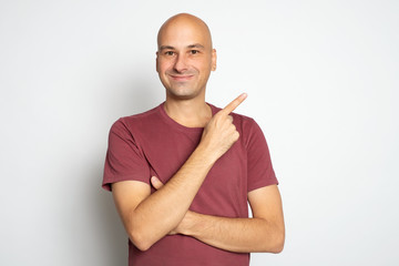 Happy smiling bald man is pointing finger. Isolated