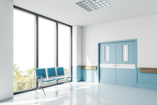 Blue chairs near window in empty hospital hall