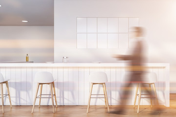 Man walking in white pub with bar counter