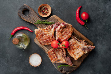 grilled beef steak with spices on a cutting board on a stone background