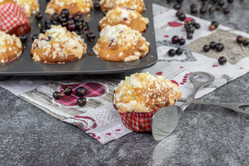 confectionery tongs with black currant muffin with crumb on a marble desk
