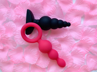 Sex toys. Two anal plug, butt plag. Pink background. Useful for sex shop, adult