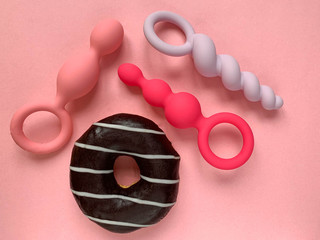 Sex toys. Donut and butt plags on a pink background. Useful for sex shop, adult