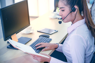 Young customer service women agent with headsets and computer working at office.