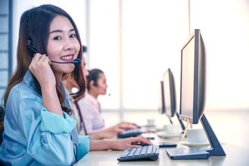 Young customer service women agent with headsets and computer working at office.