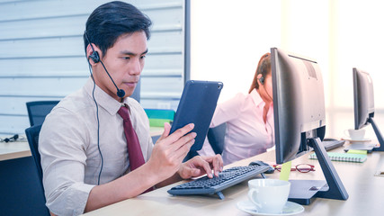 Young customer service men agent with headsets and computer working at office.