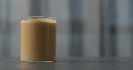 coffee with cream in glass on concrete countertop