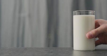 man hand take glass with white yogurt on concrete countertop