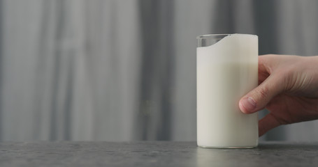 man hand take glass with white yogurt on concrete countertop