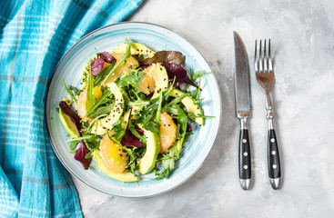 Vegan grapefruit, avocado and arugula salad on concrete background.
