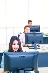 Young customer service women agent with headsets and computer working at office.