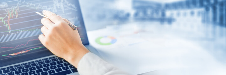 Woman shows at graph on laptop or notebook. Computer screen with graphics of chart. Wide banner or panorama technology concept.