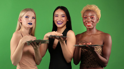 Beautiful Girls White European,Asian and Black African American Sexy young womens with Natural Healthy Skin Smiling on an isolated background.Dancing and scattering dollars.Party fun and happiness