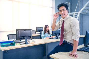 Young customer service men agent with headsets and computer working at office.