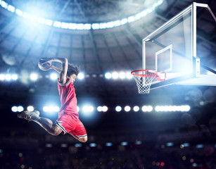 Jumping Player throws the ball in the basket in the stadium full of spectators © alphaspirit