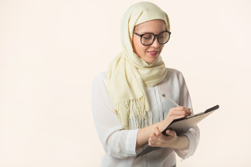 beautiful young woman in a muslim shawl with a folder in her hands