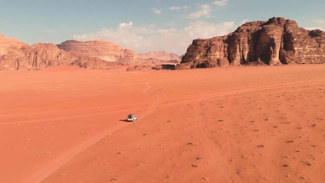 Car driving through the most epic red desert - Wadi Rum in Jordan, off-road