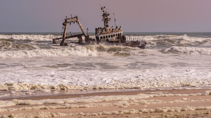 A shipwreck stranded on the beach in the Atlantic Ocean in the Skeleton Coast National Park in Namibia.