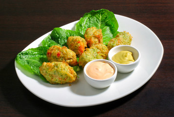 plate with vegetable cutlets on lettuce and sauce