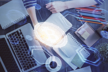 Cryptocurrency hologram, bitcoin, ico theme over hands taking notes background. Concept of...