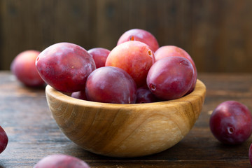Fototapeta na wymiar Ripe plums in a wooden bowl. Fresh fruits.