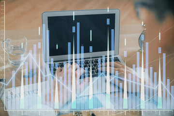 Multi exposure of market chart with man working on computer on background. Concept of financial analysis.