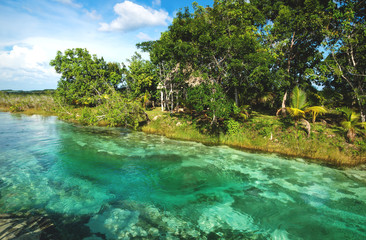Rapids at seven colored lagoon surrounded by tropical plants in Bacalar, Quintana Roo, Mexico