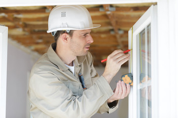 repairman taking measures with tape measure light effect