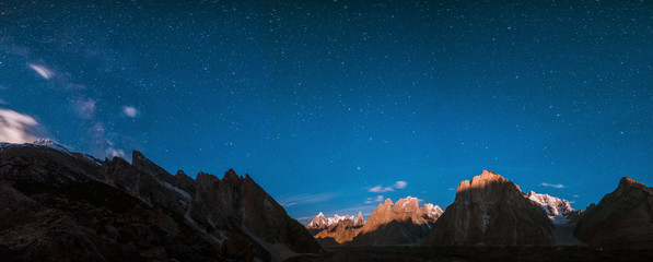 Starry night panoramic view of Baltoro Glacier and milky way behind Urdukas with Paiju, Uli Biaho,...