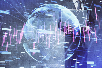 Fototapeta premium Forex graph with businessman working on laptop on background. Concept of hardworking. Multi exposure.