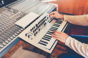 male professional producer, composer designing sound for movie music score in recording studio