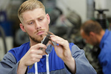 an apprentice using vernier gauage